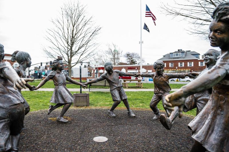 statues of children in a circle in a park